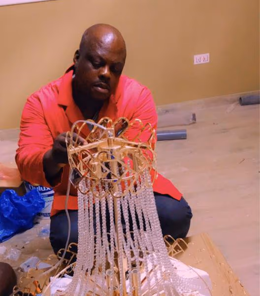 An electrician on JumaLink assembling a crystal chandelier for a client